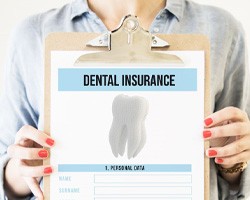 Person holding clipboard with dental insurance information
		  