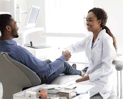 Patient and dental team member shaking hands, discussing payment options