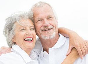 Smiling couple with dental implants in Enfield