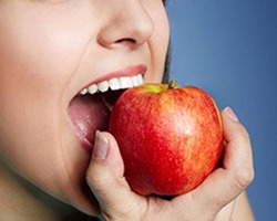 patient with dental implants in Enfield eating an apple