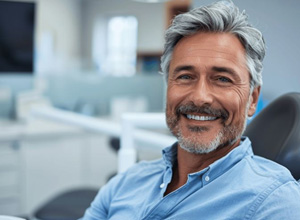 Happy middle-aged dental patient in treatment chair