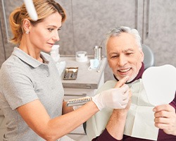 Mature man interacting with dental team member