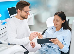 Patient signing paperwork in dentist’s office