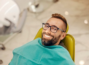 Happy, smiling dental patient in treatment chair