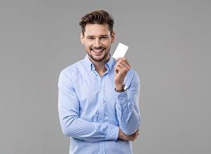 Handsome, smiling man holding payment card